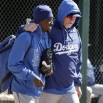 Los Angeles Dodgers shortstop Dee Gordon, left, smiles while walking with hitting coach Mark McGwire before a exhibition spring training baseball game against the Chicago White Sox in Glendale, Ariz., Sunday, Feb. 24, 2013. (AP Photo/Paul Sancya)