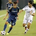 Los Angeles Galaxy's Hector Jimenez (16) woks with the ball next to Real Madrid's Francisco Alarcon during the first half of an International Champions Cup soccer match Thursday, Aug. 1, 2013, in Glendale, Ariz. (AP Photo/Matt York)