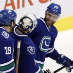 Vancouver Canucks' Chris Higgins (20) celebrates his game winning goal against the Phoenix Coyotes with teammates Roberto Luongo and Tom Sestito during overtime NHL hockey action in Vancouver, British Columbia, on Friday Dec. 6, 2013. (AP Photo/The Canadian Press, Ben Nelms)
