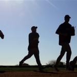 Led by Texas Rangers starting pitcher Yu Darvish, right, pitchers are silhouetted as they run between drills during a spring training baseball workout on Thursday, Feb. 14, 2013, in Surprise, Ariz. (AP Photo/Charlie Riedel)