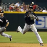 Miami Marlins' Adeiny Hechavarria, right, throws to first base to get Arizona Diamondbacks' Martin Prado out as Marlins' Ed Lucas looks on during the fourth inning of a baseball game on Monday, June 17, 2013, in Phoenix. (AP Photo/Ross D. Franklin)