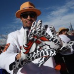 Denver Broncos fan Justin Grimmett, of Denver, shows off his gloves printed with the team logo as he waits to watch the Broncos face the New England Patriots in the AFC Championship NFL football game in Denver, Sunday, Jan. 19, 2014. (AP Photo/David Zalubowski)