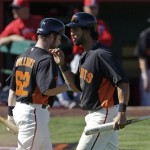 San Francisco Giants' Angel Pagan, right, is congratulated by Jackson Williams after Pagan scored during the fourth inning of an exhibition spring training baseball game against the Los Angeles Angels Saturday, Feb. 23, 2013, in Scottsdale, Ariz. (AP Photo/Darron Cummings)
