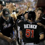 Miami Marlins' Derek Dietrich (51) is greeted in the dugout after scoring on a hit by teammate Adeiny Hechavarria during the fourth inning of a baseball game against the Arizona Diamondbacks, Tuesday, June 18, 2013, in Phoenix. (AP Photo/Matt York)