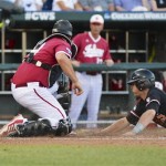Oregon State's Kavin Keyes, right, scores at home plate as the ball gets away from Indiana catcher Kyle Schwarber, on a sacrifice fly by Jake Rodriguez in the fourth inning of an NCAA College World Series elimination baseball game in Omaha, Neb., Wednesday, June 19, 2013. (AP Photo/Ted Kirk)