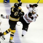 Boston Bruins center Chris Kelly (23) checks Chicago Blackhawks defenseman Michal Rozsival (32), of the Czech Republic, during the first period in Game 3 of the NHL hockey Stanley Cup Finals in Boston, Monday, June 17, 2013. (AP Photo/Charles Krupa)