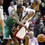 Miami Heat's Mario Chalmers, right, defends against Boston Celtics' Rajon Rondo (9) as Miami's Shane Battier, rear, watches during the first half of their NBA basketball game, Tuesday, Oct. 30, 2012, in Miami. (AP Photo/J Pat Carter)