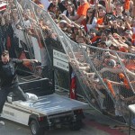 San Francisco Giants relief pitcher Brian Wilson jumps on a golf cart as a fence starts tipping while celebrating with fans at Civic Center Plaza during the Giants' World Series victory celebration in San Francisco, Wednesday, Nov. 3, 2010. (AP Photo/Mike Adaskaveg)