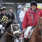 Jockey Gary Stevens, left, clenches his fist aboard Oxbow, as outrider Clark Kelly guides them to the winner's circle after winning the 138th Preakness Stakes horse race at Pimlico Race Course, Saturday, May 18, 2013, in Baltimore. (AP Photo/Garry Jones)

