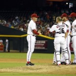 Arizona Diamondbacks manager Kirk Gibson, left, talks to his battery in the fourth inning during a baseball game against the Cincinnati Reds, Friday, June 21, 2013, in Phoenix. (AP Photo/Rick Scuteri)