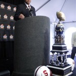 Stanford coach David Shaw answers reporters' questions behind the Fiesta Bowl Championship trophy during a news conference upon arrival to play Oklahoma State in the Fiesta Bowl college football game Monday, Dec. 26, 2011at Sky Harbor International Airport in Phoenix. (AP Photo/Paul Connors)