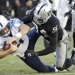 Oakland Raiders outside linebacker Kevin Burnett, right, tackles Tennessee Titans quarterback Ryan Fitzpatrick (4) during the fourth quarter of an NFL football game in Oakland, Calif., Sunday, Nov. 24, 2013. (AP Photo/Ben Margot)
