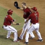 Arizona Diamondbacks' Willie Bloomquist, center, celebrates his game-winning walkoff hit with teammates Adam Eaton, who scored the winning run, and first base coach Steve Sax (5) in the 10th inning of a baseball game against the Toronto Blue Jays on Wednesday, Sept. 4, 2013, in Phoenix. The Diamondbacks defeated the Blue Jays 4-3. (AP Photo/Ross D. Franklin)