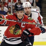 Chicago Blackhawks' Jonathan Toews (19) and Washington Capitals' Troy Brouwer (20) battle as they chase the puck during the second period of an NHL hockey game on Tuesday, Oct. 1, 2013, in Chicago. (AP Photo/Nam Y. Huh)
