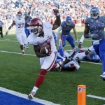 Oklahoma wide receiver Sterling Shepard (3) scores a touchdown past Kansas linebacker Victor Simmons (27) during the second half of an NCAA college football game in Lawrence, Kan., Saturday, Oct. 19, 2013. (AP Photo/Orlin Wagner)