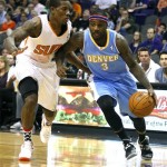 Denver Nuggets point guard Ty Lawson (3), right, drives past Phoenix Suns point guard Eric Bledsoe (2) in the first quarter during an NBA basketball game on Friday, Nov. 8, 2013, in Phoenix. (AP Photo/Rick Scuteri)
