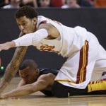 USC's J.T. Terrell (20) and Utah's Glen Dean dive for a loose ball in the closing seconds of the game during a Pac-12 tournament NCAA college basketball game on Wednesday, March 13, 2013, in Las Vegas. Utah won 69-66. (AP Photo/Julie Jacobson)