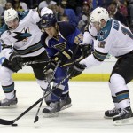 San Jose Sharks' Douglas Murray, left, of Sweden, and Patrick Marleau, right, reach for a loose puck alongside St. Louis Blues' Chris Stewart during the second period of Game 1 of an NHL hockey first-round playoff series on Thursday, April 12, 2012, in St. Louis. (AP Photo/Jeff Roberson)