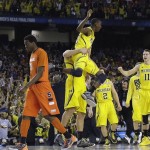 Michigan's Caris LeVert (23) celebrates with team mates as Syracuse's Jerami Grant (3) walks off the court during the second half of the NCAA Final Four tournament college basketball semifinal game Saturday, April 6, 2013, in Atlanta. Michigan won 61-56. (AP Photo/David J. Phillip)
