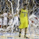 Michigan guard Trey Burke (3) walks off the court as Louisville celebrate their win during the second half of the NCAA Final Four tournament college basketball championship game Monday, April 8, 2013, in Atlanta. Louisville won 82-76. (AP Photo/Charlie Neibergall)