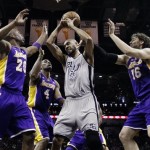 San Antonio Spurs' Tim Duncan (21) grabs a rebound between Los Angeles Lakers' Jodie Meeks (20), Antawn Jamison (4) and Pau Gasol (16) during the first half of Game 1 of their first-round NBA playoff basketball series, Sunday, April 21, 2013, in San Antonio. (AP Photo/Eric Gay)