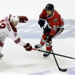  Phoenix Coyotes' Oliver Ekman-Larsson, left, and Chicago Blackhawks' Brandon Bollig battle for the puck during the third period of an NHL hockey game in Chicago, Thursday, Nov. 14, 2013. The Blackhawks won 5-4. (AP Photo/Nam Y. Huh)