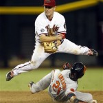 Arizona Diamondbacks second baseman Aaron Hill (2) turns the double play while avoiding Baltimore Orioles right fielder Nick Markakis (21) in the ninth inning during a baseball game on Tuesday, Aug. 13, 2013, in Phoenix. (AP Photo/Rick Scuteri)
