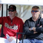 Arizona Diamondbacks manager Kirk Gibson, left, and general manager Kevin Towers ride to the practice fields during the teams' first baseball spring training workout, Friday, Feb. 7, 2014, in Scottsdale, Ariz. (AP Photo/Matt York)