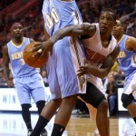 Phoenix Suns point guard Eric Bledsoe (2), right, makes the pass around the back of Denver Nuggets power forward Darrell Arthur (00) in the fourth quarter during an NBA basketball game on Friday, Nov. 8, 2013, in Phoenix. The Suns defeated the Nuggets 114-93. (AP Photo/Rick Scuteri)
