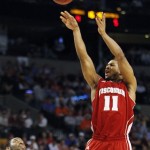 Wisconsin guard Jordan Taylor (11) shoots over Syracuse guard Scoop Jardine (11) during the first half of an East Regional semifinal game in the NCAA men's college basketball tournament, Thursday, March 22, 2012, in Boston. (AP Photo/Michael Dwyer)