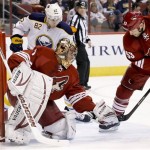  With the help of Phoenix Coyotes' Derek Morris (53), Coyotes goalie Thomas Greiss (1), of Germany, makes a save on a shot as Buffalo Sabres' Marcus Foligno (82) looks on during the first period of an NHL hockey game on Thursday, Jan. 30, 2014, in Glendale, Ariz. (AP Photo)