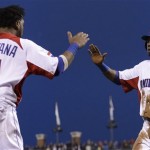 The Dominican Republic's Alejandro De Aza (30) is congratulated by Carlos Santana after scoring against Puerto Rico during the fifth inning of the championship game of the World Baseball Classic in San Francisco, Tuesday, March 19, 2013. (AP Photo/Ben Margot)