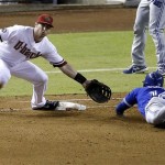 Toronto Blue Jays' Mark DeRosa dives back safely to first base on a fly out as Arizona Diamondbacks' Paul Goldschmidt misses the throw during the fourth inning of a baseball game, Tuesday, Sept. 3, 2013, in Phoenix. DeRosa advanced to third on the error. (AP Photo/Matt York)