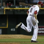 Arizona Diamondbacks' A.J. Pollock (11) jogs to first base after earning a walk against Philadelphia Phillies' Cole Hamels, left, during the fifth inning of a baseball game on Thursday, May 9, 2013, in Phoenix. (AP Photo/Ross D. Franklin)