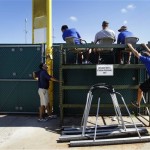 Members of the Roger Dean Stadium groundskeeping crew wait behind the right field wall for the end of a spring training baseball game between the Houston Astros and the Miami Marlins in Jupiter, Fla., Monday, March 19, 2012. (AP Photo/Patrick Semansky)