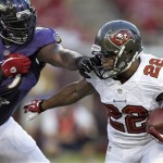Baltimore Ravens defensive tackle Chris Canty grabs Tampa Bay Buccaneers running back Doug Martin (22) by the facemask during the first quarter of an NFL preseason football game Thursday, Aug. 8, 2013, in Tampa, Fla. (AP Photo/Chris O'Meara)
