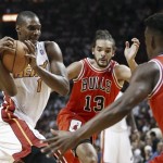  Miami Heat's Chris Bosh (1) tries to drive between Chicago Bulls' Joakim Noah (13) and Jimmy Butler (22) during the first half of an NBA basketball game in Miami, Tuesday, Oct. 29, 2013. (AP Photo/J Pat Carter)