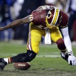 
Washington Redskins quarterback Robert Griffin III twists his knees as he reaches for the loose ball after a low snap during the second half of an NFL wild card playoff football game against the Seattle Seahawks in Landover, Md., Sunday, Jan. 6, 2013. (AP Photo/Matt Slocum)
