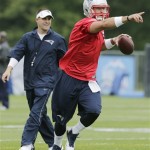 New England Patriots quarterback Tim Tebow points to a receiver as he drops back on a passing route as offensive coordinator Josh McDaniels, left, looks on during NFL football practice in Foxborough, Mass., Tuesday June 11, 2013. (AP Photo/Charles Krupa)