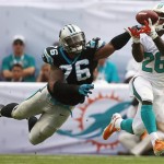 Miami Dolphins running back Lamar Miller (26) grabs a pass as Carolina Panthers defensive end Greg Hardy (76) applies pressure during the first half of an NFL football game on Sunday, Nov. 24, 2013, in Miami Gardens, Fla. (AP Photo/J Pat Carter)