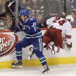 Vancouver Canucks' Dale Weise (32) checks Phoenix Coyotes' Kyle Chipchura (24) during second period NHL hockey action in Vancouver, British Columbia, on Friday Dec. 6, 2013. (AP Photo/The Canadian Press, Ben Nelms)
