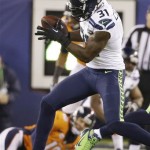 Seattle Seahawks' Kam Chancellor intercepts a pass by Denver Broncos' Peyton Manning, on ground in background, during the first half of the NFL Super Bowl XLVIII football game Sunday, Feb. 2, 2014, in East Rutherford, N.J. (AP Photo/Mark Humphrey)