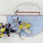 Goalkeeper Kim Martin Hasson of Sweden blocks a shot by Jocelyne Lamoureux of the United States as Lina Backlin of Sweden defends during the third period of the 2014 Winter Olympics women's semifinal ice hockey game at Shayba Arena, Monday, Feb. 17, 2014, in Sochi, Russia. The USA won 6-1. (AP Photo/Matt Slocum)