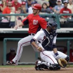Washington Nationals' Bryce Harper runs behind Atlanta Braves catcher Christian Bethancourt to score a run during the fifth inning of a spring training baseball game Tuesday, Feb. 26, 2013, in Kissimmee, Fla. (AP Photo/David J. Phillip)