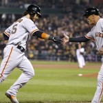 San Francisco Giants' Brandon Crawford, left, is greeted by third base coach Tim Flannery after hitting a grand slam against the Pittsburgh Pirates in the fourth inning of the NL wild-card playoff baseball game Wednesday, Oct. 1, 2014, in Pittsburgh. (AP Photo/Gene J. Puskar)