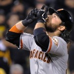 San Francisco Giants' Brandon Crawford points skyward as he heads home after hitting a grand slam during the fourth inning of the NL wild-card playoff baseball game against the Pittsburgh Pirates on Wednesday, Oct. 1, 2014, in Pittsburgh. (AP Photo/Don Wright)