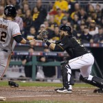 San Francisco Giants' Joe Panik (12) is forced out at home as Pittsburgh Pirates catcher Russell Martin makes the catch from second baseman Neil Walker in the seventh inning of the NL wild-card playoff baseball game Wednesday, Oct. 1, 2014, in Pittsburgh. (AP Photo/Gene J. Puskar)