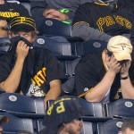 Pittsburgh Pirates fans cover their faces as they watch the NL wild-card playoff baseball game against the San Francisco Giants in the ninth inning Wednesday, Oct. 1, 2014, in Pittsburgh. The Giants won 8-0. (AP Photo/Don Wright)