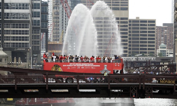 Chicago Blackhawks players, with the Stanley Cup, ride in an open top bus across the Monroe Street ...