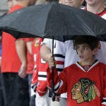 
              A young boy stands in the rain as he waits outside the United Center before the start of Game 4 of the NHL hockey Stanley Cup Final between the Chicago Blackhawks and the Tampa Bay Lightning Wednesday, June 10, 2015, in Chicago. (AP Photo/Nam Y. Huh)
            